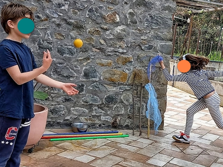 Un bambino si allena con le palline e una bambina con le stoffe