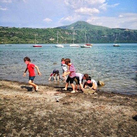 Un gruppo di bambini gioca in riva al lago Albano.